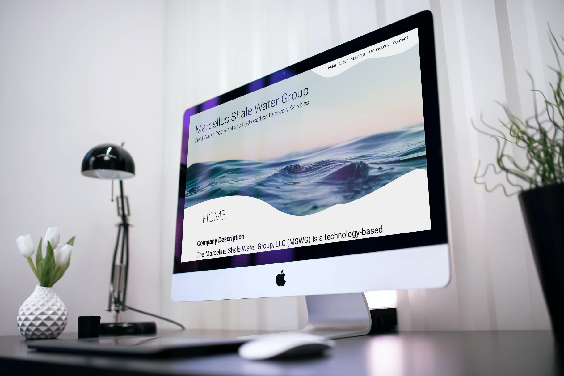 A computer displaying the splash screen of a modern looking website with photo header of water swirls